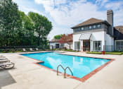 Thumbnail 12 of 24 - a swimming pool with lounge chairs and a building in the background at Lincoln at Wolfchase, Cordova, TN 38016