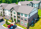 Thumbnail 25 of 28 - an aerial view of an apartment building with cars parked outside