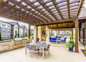 Thumbnail 18 of 28 - a patio with a table and chairs and a pergola