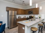 Thumbnail 1 of 28 - a kitchen with stainless steel appliances and granite counter tops at The McKenzie Park Apartments, Little Rock