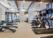 Thumbnail 20 of 28 - a gym with treadmills and other exercise equipments in a room with windows