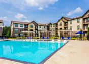 Thumbnail 14 of 28 - a swimming pool with an apartment building in the background