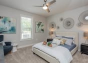 Thumbnail 12 of 28 - a bedroom with a bed and a ceiling fan