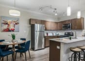 Thumbnail 2 of 28 - a kitchen with stainless steel appliances and a table with chairs