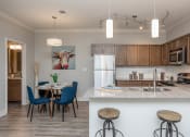 Thumbnail 4 of 28 - a kitchen and dining area with a table and chairs and a refrigerator