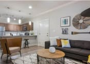 Thumbnail 6 of 28 - a living room and kitchen with a couch and a table