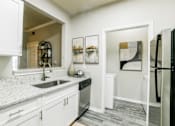 Thumbnail 2 of 23 - A kitchen with a black refrigerator and white cabinets. at Madison Shelby Farms, Memphis