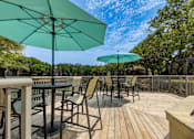 Thumbnail 43 of 58 - A patio with chairs and tables under umbrellas.