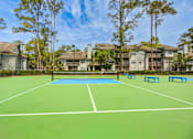 Thumbnail 45 of 58 - A tennis court with a net and four blue benches.