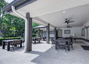 Thumbnail 52 of 58 - A patio with a table and chairs under a roof.