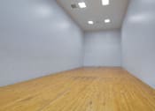 Thumbnail 35 of 58 - A room with wooden flooring and white walls.