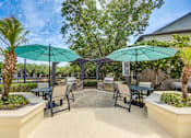 Thumbnail 50 of 58 - A patio with tables and chairs under umbrellas.