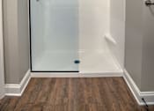 Thumbnail 9 of 15 - A white bathroom with a glass shower door.