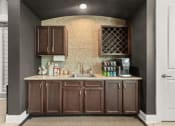 Thumbnail 25 of 31 - a rendering of a kitchen with brown cabinets and a counter at The Ridge at Chenal Valley, Arkansas