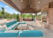 Thumbnail 16 of 31 - a covered patio with blue couches and a fireplace at The Ridge at Chenal Valley, Little Rock