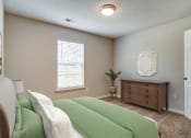 Thumbnail 5 of 13 - a bedroom with a bed and a dresser and a window  at Serene at Creekstone, Georgia, 30601