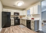 Thumbnail 1 of 13 - an open kitchen with black appliances and white cabinets  at Serene at Creekstone, Athens, Georgia