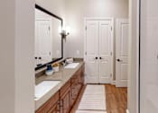 Thumbnail 8 of 15 - A bathroom with a sink, mirror, and white door.