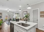 Thumbnail 2 of 43 - A modern kitchen with a large island and a stainless steel dishwasher.