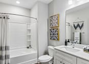 Thumbnail 11 of 43 - A white bathroom with a toilet, sink, and shower.