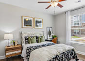 Thumbnail 9 of 43 - A bedroom with a large bed and a ceiling fan.