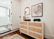Thumbnail 8 of 25 - A white wooden dresser with a mirror and a painting on the wall.at Parkview Apartments, Memphis, 38104