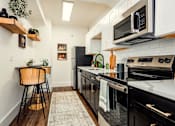 Thumbnail 2 of 25 - A kitchen with black appliances and white cabinets. at Parkview Apartments, Memphis, TN