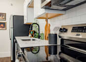Thumbnail 3 of 25 - A modern kitchen with a black refrigerator and stainless steel appliances.at Parkview Apartments, Memphis Tennessee