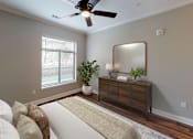 Thumbnail 6 of 15 - A living room with a white couch and a wooden dresser.