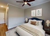 Thumbnail 7 of 15 - A bedroom with a large bed and a ceiling fan.