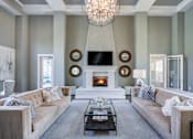 Thumbnail 36 of 38 - Living room with a fireplace and a chandelier at The Ridge at Chenal Valley Apartments, Arkansas, 72223