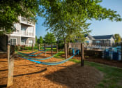 Thumbnail 19 of 27 - a playground with hammocks in front of an apartment building at The Shallowford, Chattanooga, TN, 37421