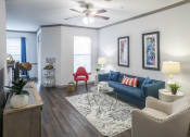 Thumbnail 3 of 27 - a living room with a blue couch and a ceiling fan