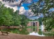 Thumbnail 26 of 29 - a pond with a fountain and a building in the background at The Summit Apartments, Tennessee, 38128