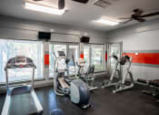 Thumbnail 8 of 29 - a gym with various exercise equipment and windows at The Summit Apartments, Memphis, TN, 38128