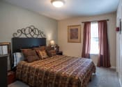 Thumbnail 5 of 29 - a bedroom with a bed and a window at The Summit Apartments, Memphis, Tennessee