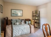 Thumbnail 7 of 29 - a bedroom with a bed with pillows and a shelf with a clock at The Summit Apartments, Memphis