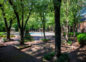 Thumbnail 12 of 29 - a view of a yard with trees and a swimming pool at The Summit Apartments, Memphis