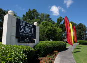Thumbnail 28 of 29 - the sign for the summit apartments in front of a lawn with colorful umbrellas at The Summit Apartments, Tennessee