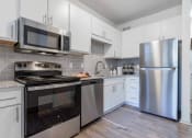 Thumbnail 1 of 14 - a kitchen with stainless steel appliances and white cabinets at The Waters at Chenal, Little Rock, Arkansas