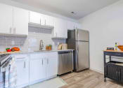 Thumbnail 2 of 14 - a kitchen with white cabinets and a stainless steel refrigerator at The Waters at Chenal, Little Rock, 72211