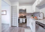 Thumbnail 3 of 14 - a kitchen with stainless steel appliances and white cabinets at The Waters at Chenal, Little Rock