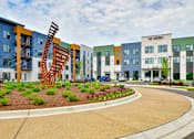 Thumbnail 29 of 29 - A modern building complex with a sculpture in the front.