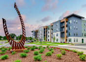 Thumbnail 1 of 29 - A modern building with a large sculpture in front of it.
