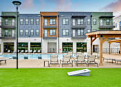 Thumbnail 10 of 29 - A modern apartment complex with a pool and lounge area.