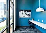 Thumbnail 24 of 29 - A blue room with a white desk and a black chair.