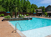 Thumbnail 11 of 26 - A swimming pool surrounded by trees and a fence. at Hall Creek Apartment Homes, Arlington, TN