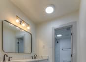 Thumbnail 16 of 24 - A bathroom with a wooden floor and white walls.at The Garden District Apartments, Tennessee  