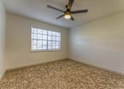 Thumbnail 13 of 24 - A room with a ceiling fan and a window with blinds.at The Garden District Apartments, Germantown  