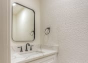 Thumbnail 10 of 24 - A white bathroom with a sink and a mirror.at The Garden District Apartments, Germantown, TN 38138  